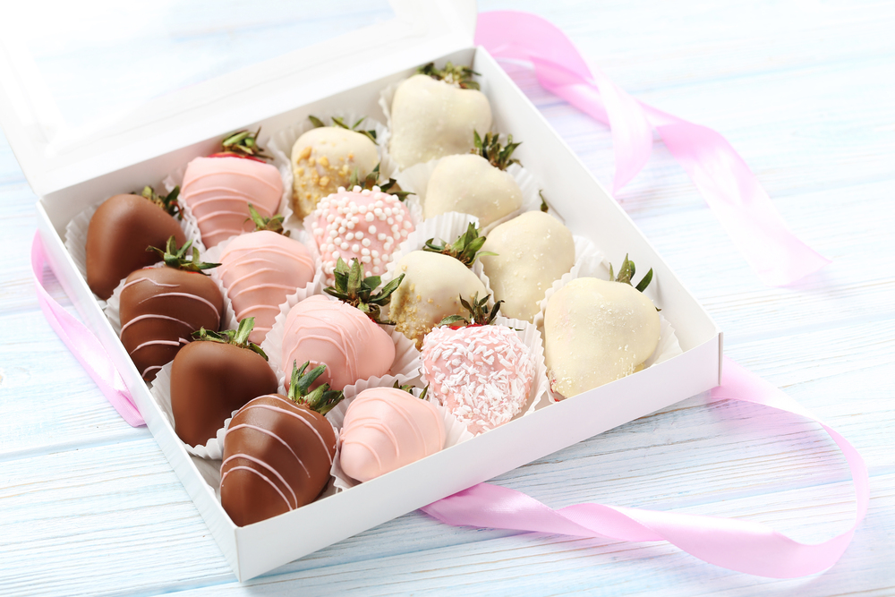 Strawberries covered in chocolate on a blue wooden table